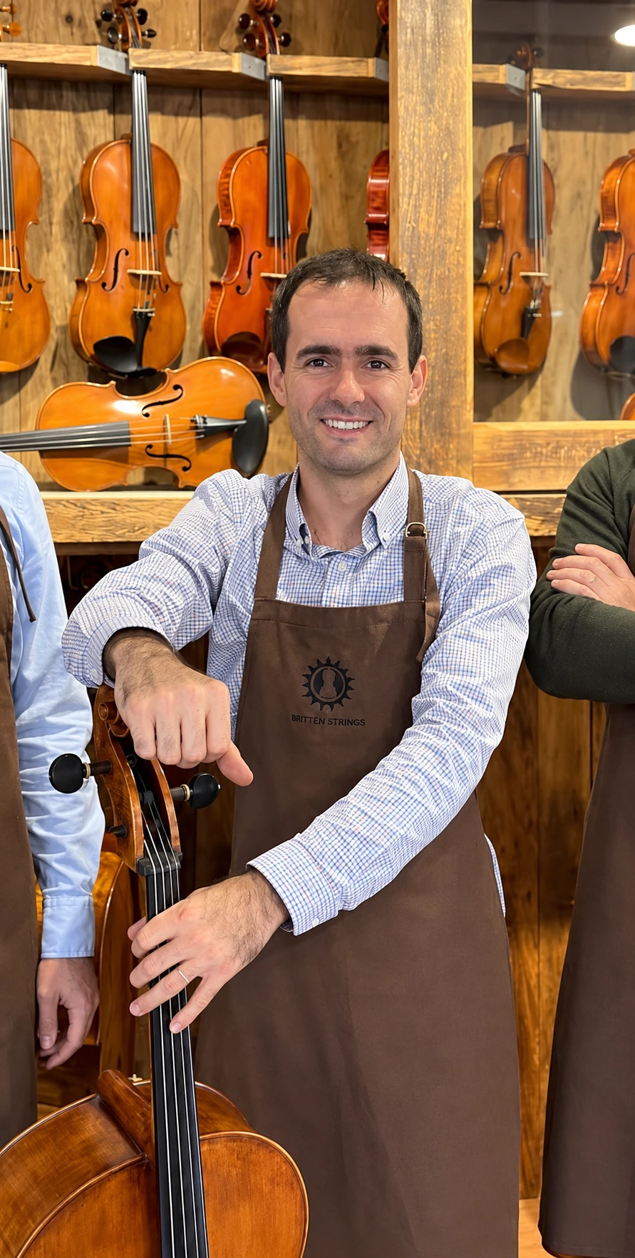 O luthier Rogério Fagundes em sua oficina com um violoncelo
